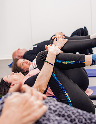 Alumnas tumbadas llevando la rodilla al pecho