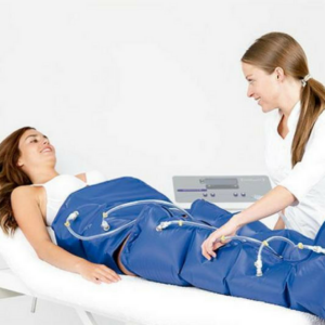 Fisioterapeuta aplicando presoterapia en las piernas de una paciente