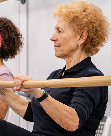 Alumna de Ballet Barre sujetando una barra de madera