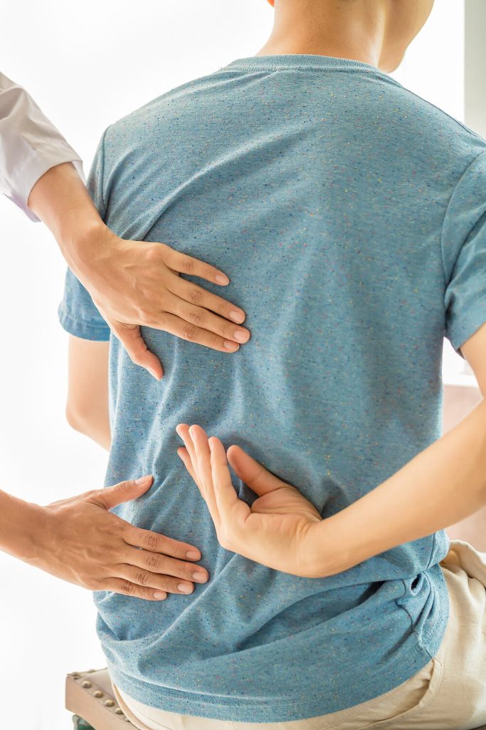 Fisioterapeuta evaluando dolor lumbar en paciente
