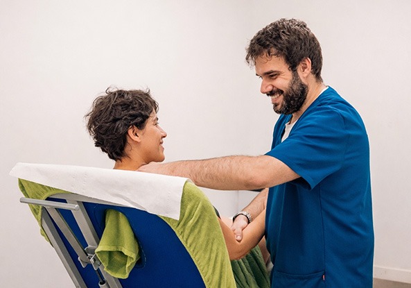 Fisioterapeuta de ASERHCO atendiendo a una paciente en la camilla